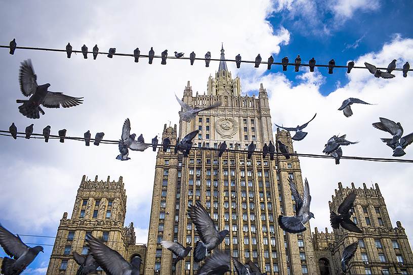 Москва, Россия. Голуби сидят на линиях электропередач на фоне здания Министерства иностранных дел