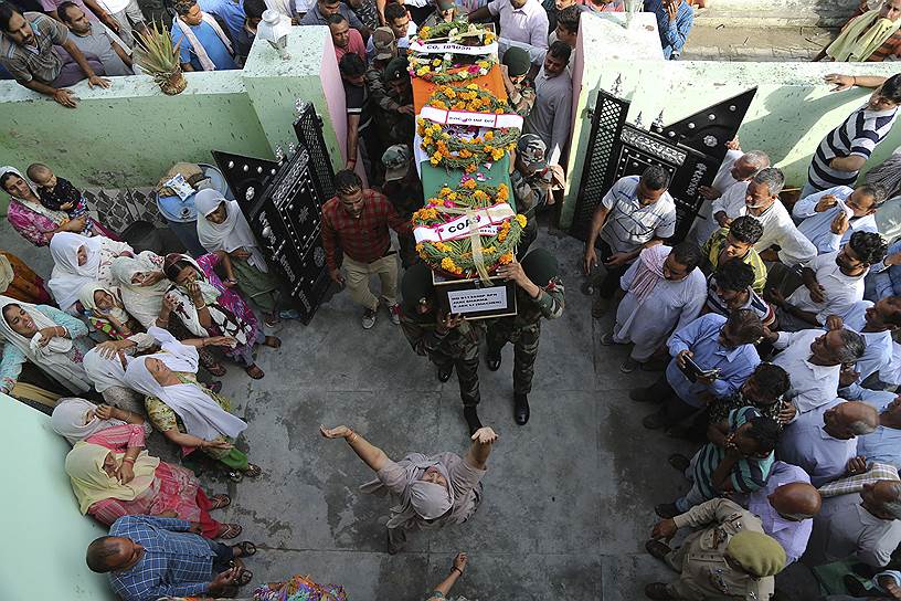 Катхуа, Индия. Военнослужащий несет тело своего убитого в перестрелке коллеги  