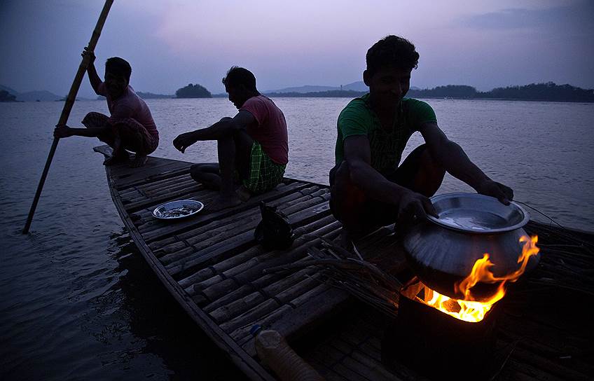 Гувахати, Индия. Рыбаки готовят пищу на судне 