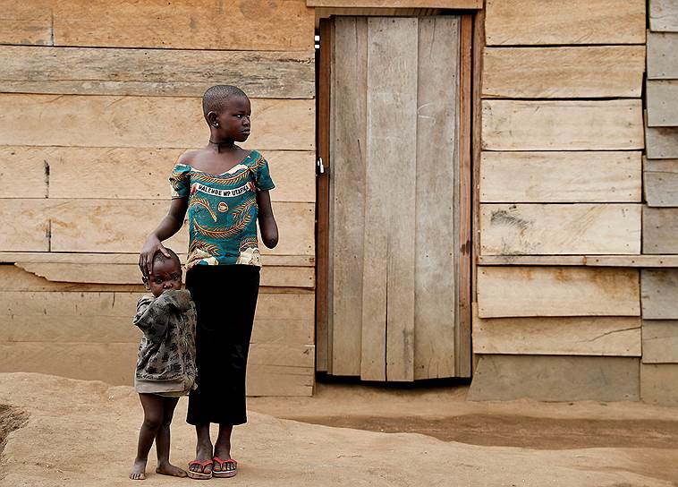 Буниа, Демократическая Республика Конго. 11-летняя девочка, пострадавшая во время атаки боевиков, вместе с двухлетней сестрой в лагере для беженцев