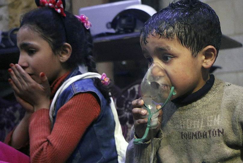 Дети дышат кислородом через респираторы после предполагаемой химической атаки
