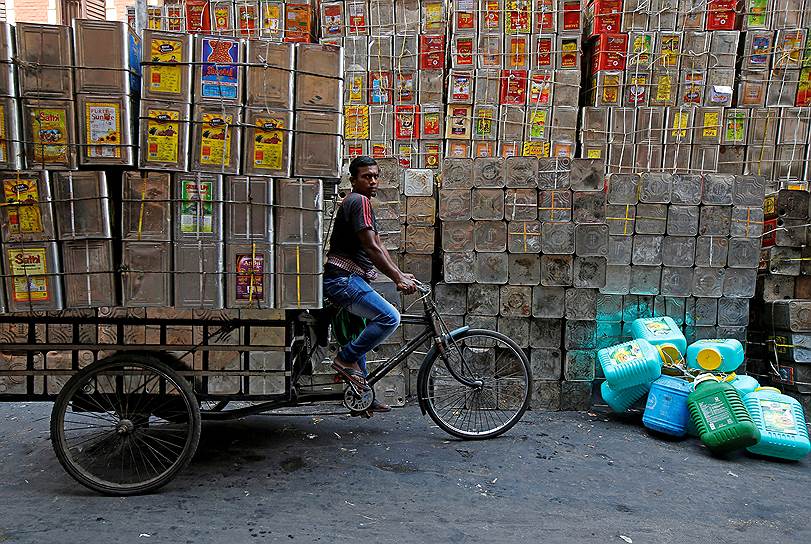 Калькутта, Индия. Местный житель везет пустые канистры из-под масла
