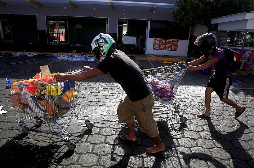 Манагуа, Никарагуа. Участники акции против пенсионной реформы убегают с награбленными товарами