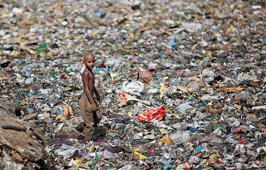 Нью-Дели, Индия. Мальчик гуляет по водосточной канаве, заполненной мусором