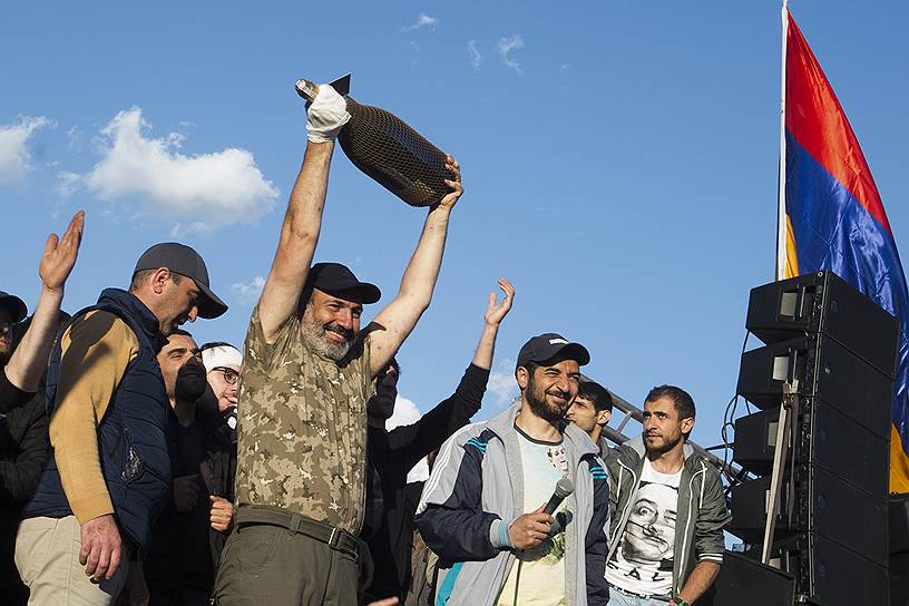 Лидер протестующих Никол Пашинян (второй слева) с бутылкой игристого вина на митинге после отставки премьера Сержа Саргсяна