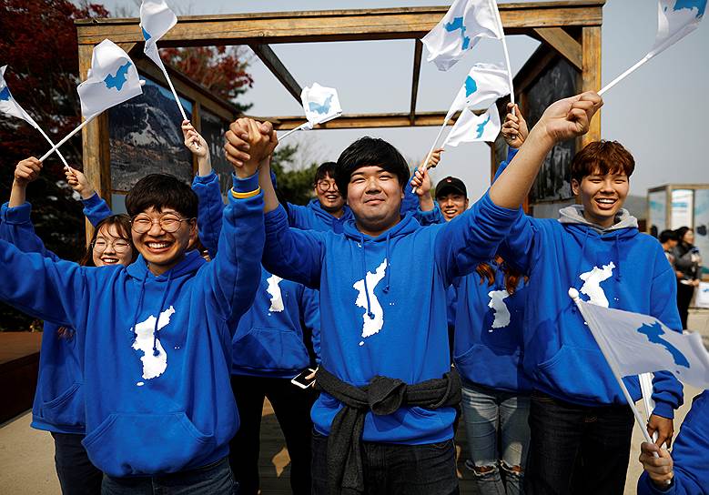 Демонстранты в приграничном городе Пхаджу машут флагами, символизирующими объединение КНДР и Южной Кореи