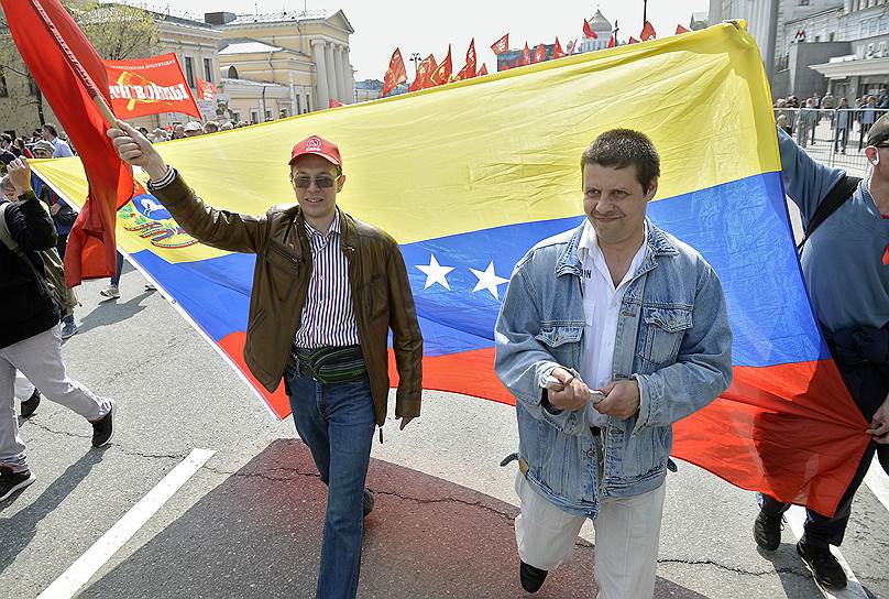 Участники шествия несут флаг Венесуэлы 