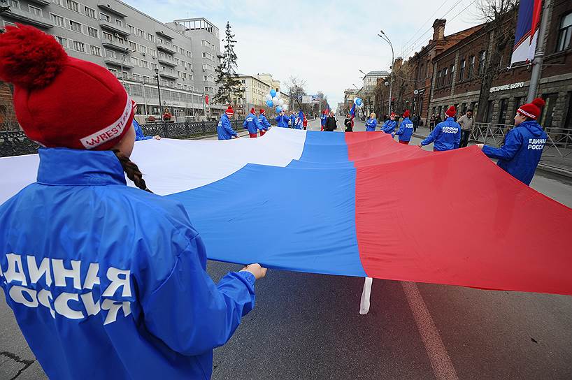 Участники первомайской демонстрации в Новосибирске несут российский флаг