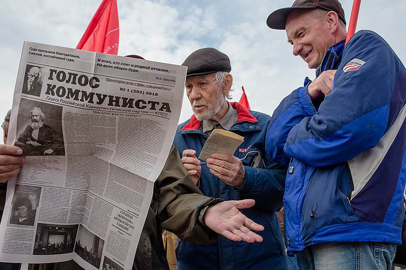 Участники демонстрации в Новосибирске читают газету