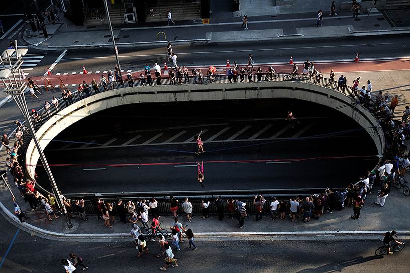 Сан-Паулу, Бразилия. Женщины идут по канатам над одной из главных магистралей города 