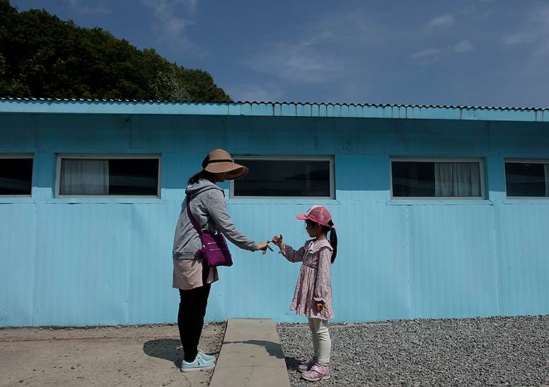 Намъянджу, Южная Корея. Женщина и маленькая девочка приветствуют друг друга особым жестом, который символизирует начало диалога между лидером КНДР Ким Чен Ыном и президентом Южной Кореи Мун Чжэ Ином 
