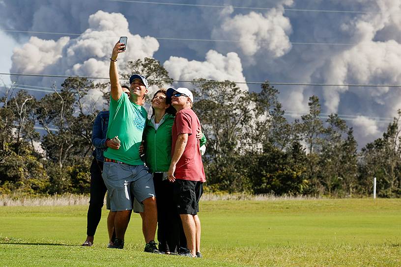 Туристы фотографируются на фоне извержения вулкана на Гавайях