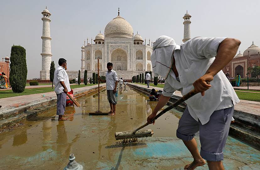 Агра, Индия. Рабочий чистит фонтан, расположенный на территории комплекса Тадж-Махал