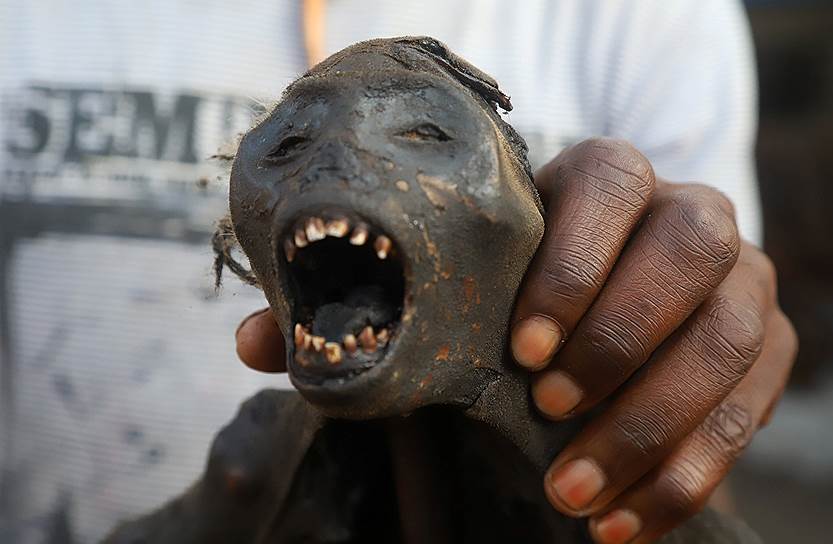 Мбандака, Демократическая Республика Конго. Продавец на рынке держит копченое мясо обезьяны во время кампании по вакцинации от вируса Эбола
