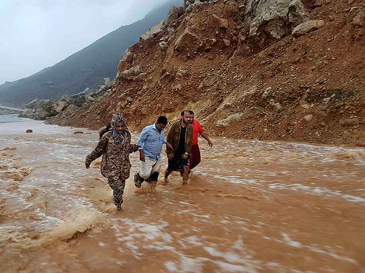 Остров Сокотра, Йемен. Мужчины идут по затопленной после проливных дождей дороге