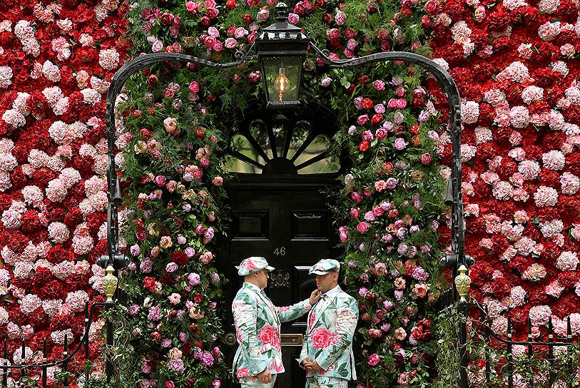 Лондон, Великобритания. Дворецкие, одетые в костюмы с изображениями цветов, на входе в частный клуб
