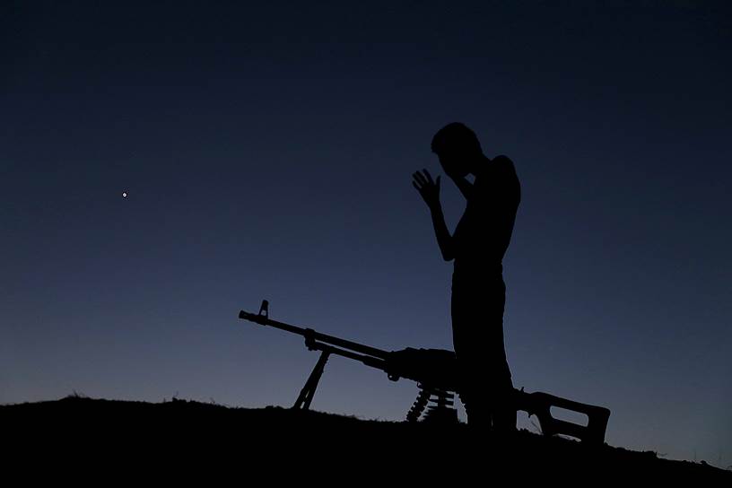 Даиль, Сирия. Боец «Свободной сирийской армии» молится после еды во время священного месяца Рамадан