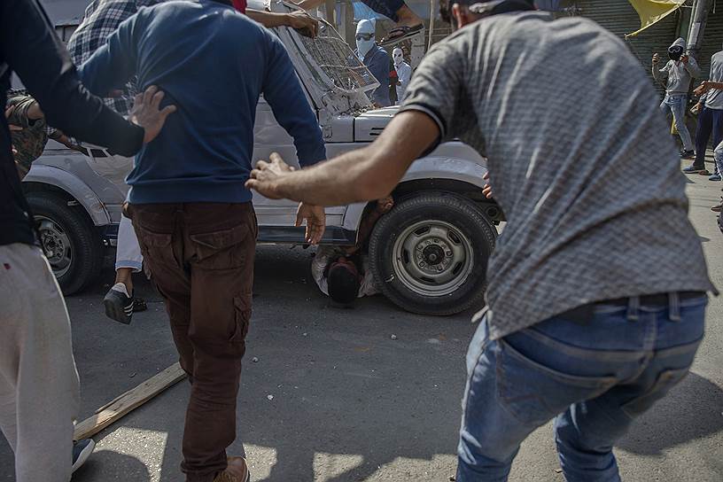 Сринагар, Индия. Кашмирские протестующие спешат на помощь товарищу, на которого наехал военный джип