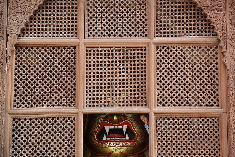 Катманду, Непал. Священнослужитель выглядывает из окна индуистского храма