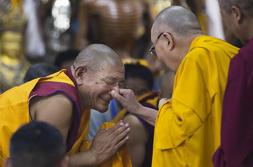 Дармсала, Индия. Далай-лама приветствует монаха в шутливой форме 