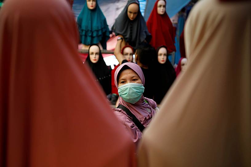 Джакарта, Индонезия. Женщина делает покупки на рынке традиционной мусульманской одежды