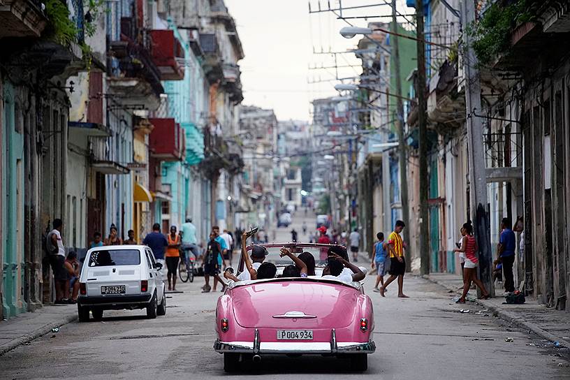 Гавана, Куба. Туристы катаются на винтажном автомобиле