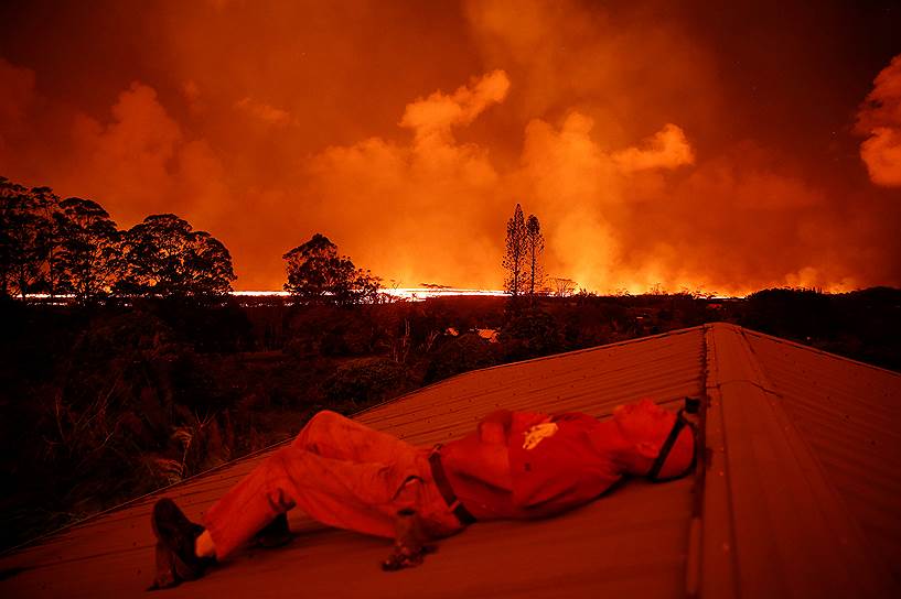 Гавайские острова, США. Местный житель наблюдает за потоками лавы во время извержения вулкана Килауэа