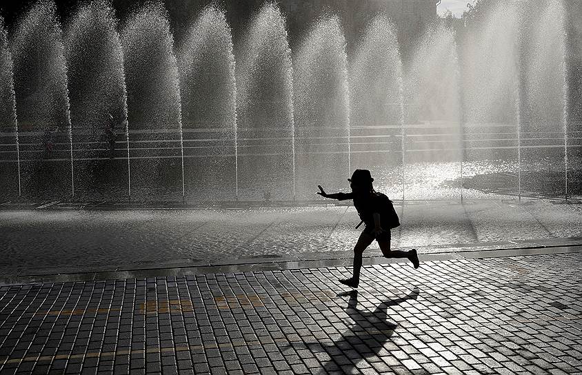 Екатеринбург, Россия. Мальчик бежит около фонтана
