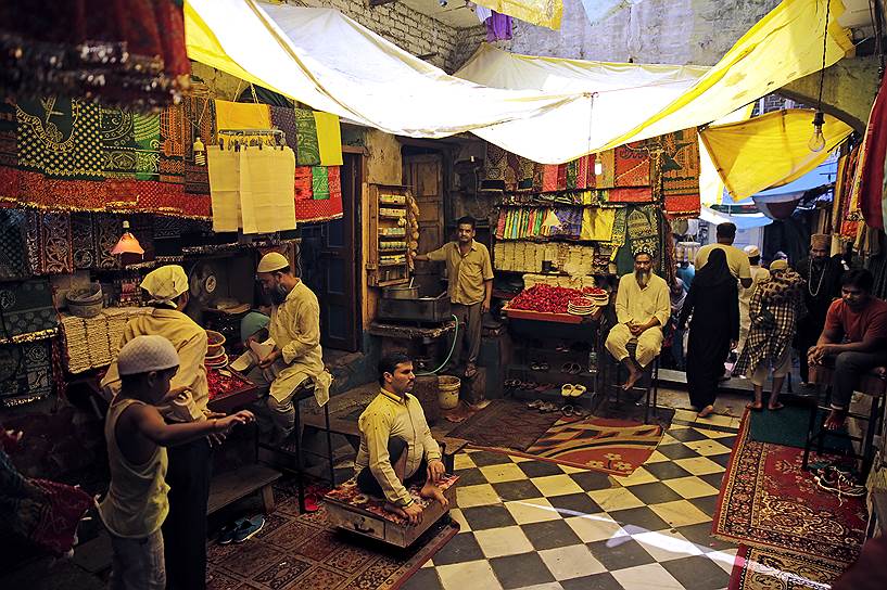 Нью-Дели, Индия. Продавцы торгуют цветами и платками перед входом в мавзолей Низамуддина — одного из самых известных суфийских святых 