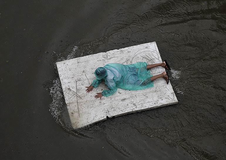 Мумбаи, Индия. Мальчик плывет на куске термопласта после муссонных дождей