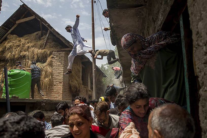 Деревня Кундалан, Индия. Сельские жители покидают дома, поврежденные в результате перестрелки индийской армии с группой вооруженных боевиков
