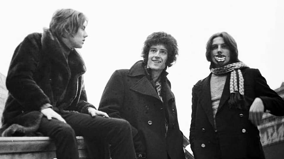В 1970 году участники рок-группы Smile Брайан Мэй (в центре) и Роджер Тейлор (слева) пригласили своего знакомого Фарруха «Фредди» Булсару в коллектив. Попав в него, он придумал новое название — «Queen», разработал логотип из знаков зодиака музыкантов, а также взял псевдоним Фредди Меркьюри. В 1971 году в группе появился четвертый участник — им стал бас-гитарист Джон Дикон, продержавшийся в коллективе более 20 лет
