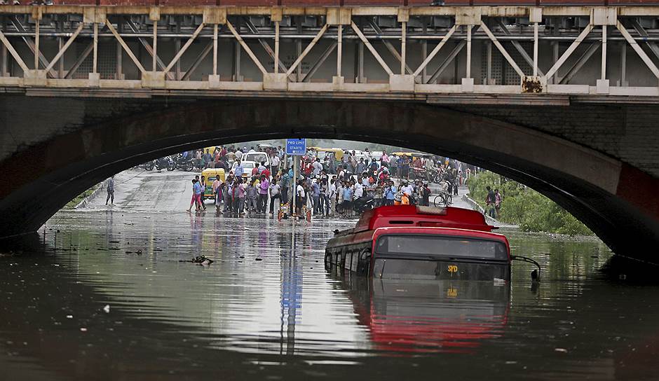 Нью-Дели, Индия. Пассажиры смотрят на погруженный в воду автобус
