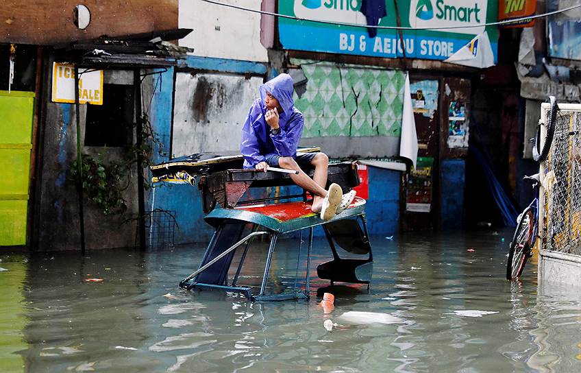 Кесон-Сити. Филиппины. Местный житель на улице, затопленной после муссонных дождей и тропического шторма