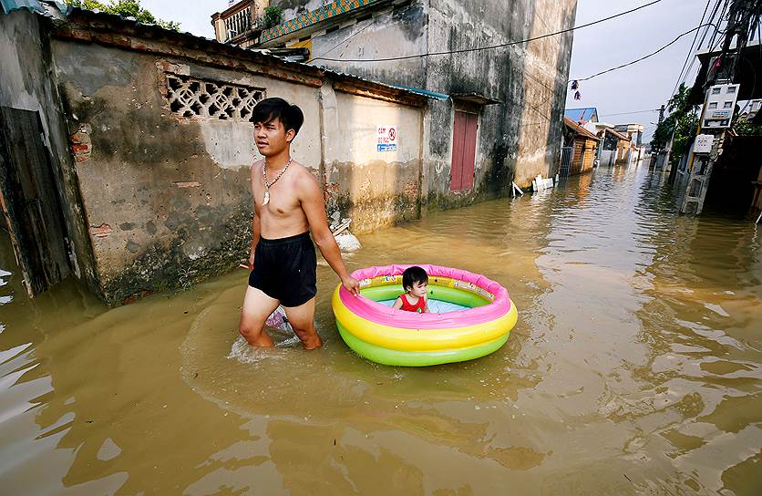 Ханой, Вьетнам. Местный житель идет по затопленной улице 