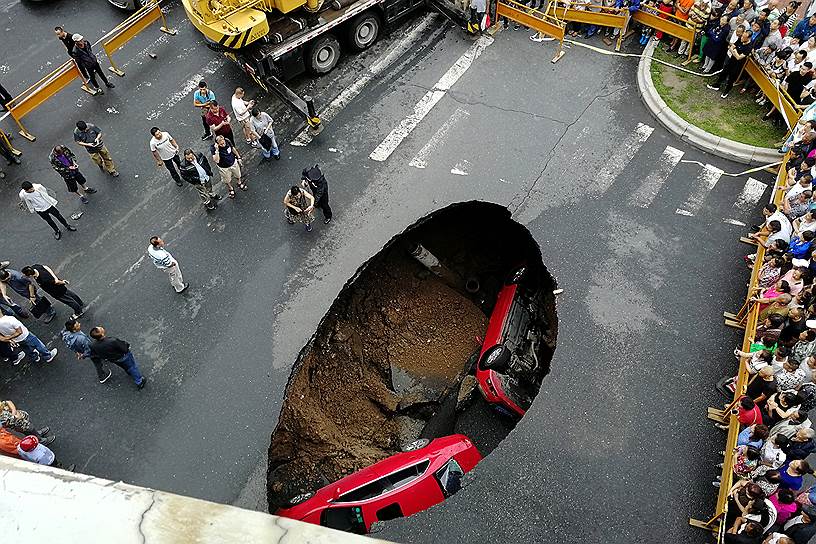 Харбин, Китай. Зеваки собрались, чтобы посмотреть на машины, провалившиеся под землю
