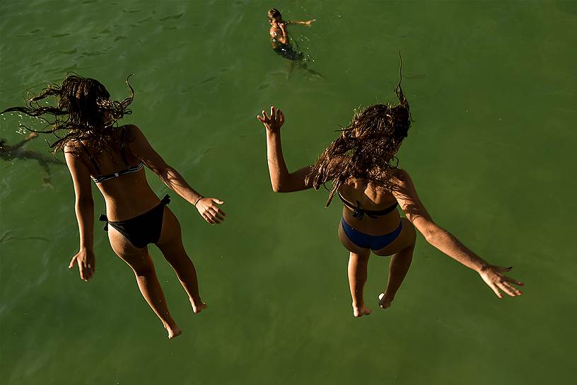 Девушки из испанского города Сан-Себастьян прыгают в воду