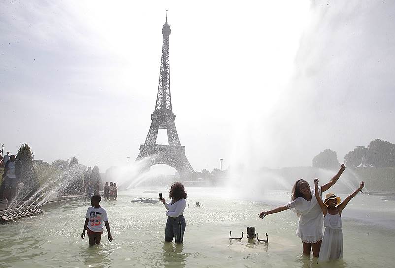 В Париже (Франция) местные жители спасаются от жары в фонтане
