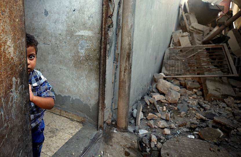 Аль-Муграка, сектор Газа. Мальчик выглядывает из дома, который подвергся авиаудару 