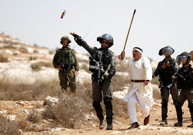 Рас Каркар, Западный берег реки Иордан. Израильский пограничник бросает шумовую гранату во время столкновений с палестинскими протестующими