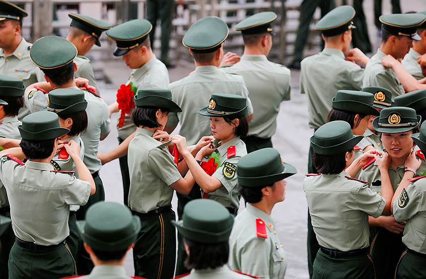 Ланьчжоу, Китай. Участницы полувоенных полицейских формирований снимают с лычек знаки различия во время прощальной церемонии