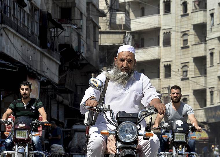 Идлиб, Сирия. Вооруженные мужчины на мотоциклах в центре города