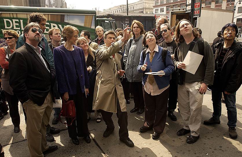Билл Браун (в центре) указывает на камеры видеонаблюдения во время пешеходной экскурсии, проводимой Surveillance Camera Players, 3 апреля 2003 года