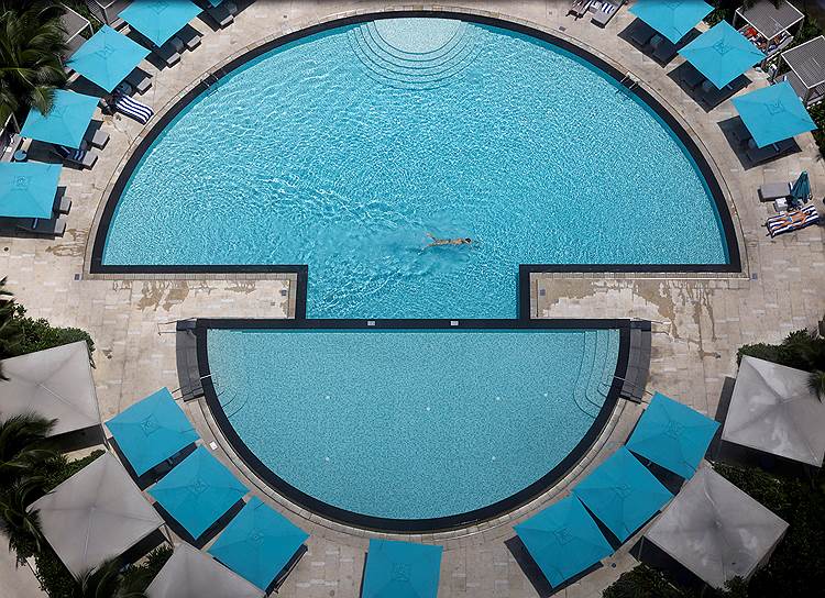 Сингапур. Мужчина плавает в бассейне одного из отелей столицы