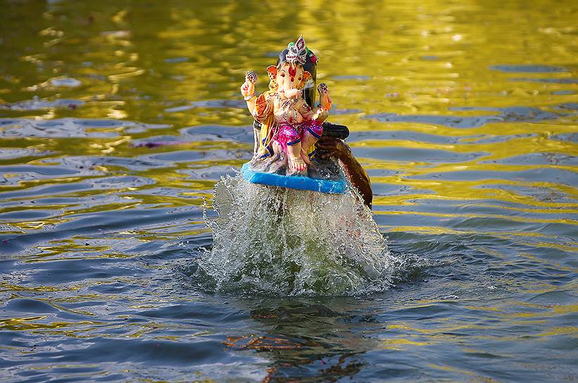 Ахмадабад, Индия. Верующие погружают в воду фигурку божества в честь праздника Ганеша-чатуртхи