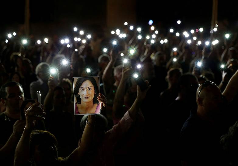Валлетта, Мальта. Местные жители держат портреты убитой год назад журналистки Дафни Гализии

