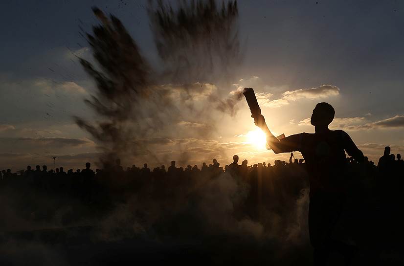 Сектор Газа. Палестинец отбрасывает дымовую шашку 