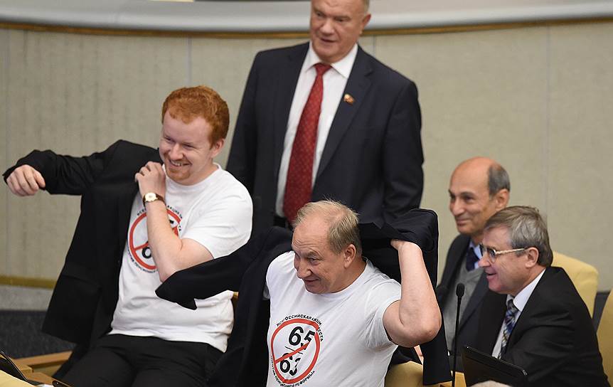 В зале пленарных заседаний группа депутатов от КПРФ устроила акцию: они пришли в футболках, на которых изображены перечеркнутые цифры 63 и 65 (возраст выхода на пенсию в первоначальной редакции законопроекта)