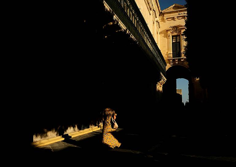Валлетта, Мальта. Женщина прогуливается у Дворца гроссмейстеров Мальтийского ордена