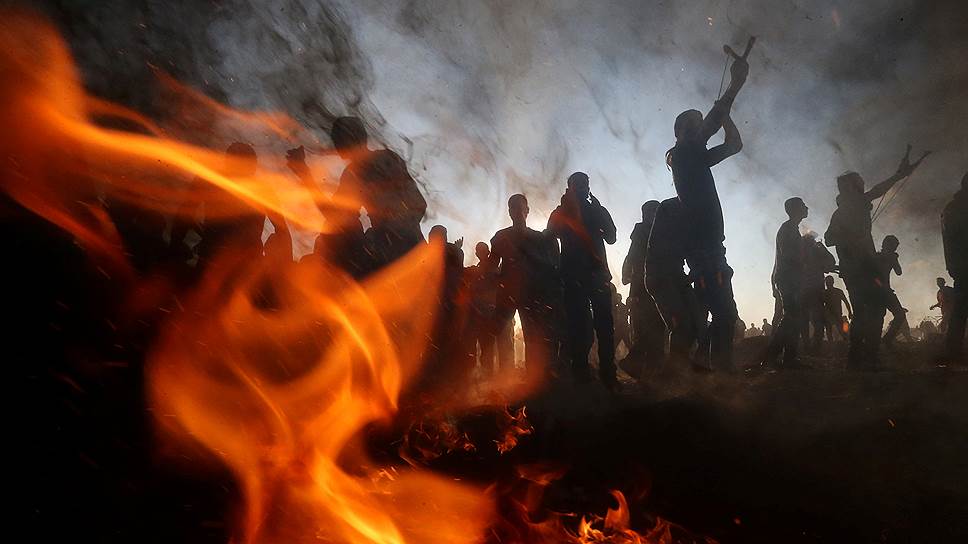 Сектор Газа. Палестинцы закидывают камнями израильских военных во время протестной акции «Великий марш возвращения» 